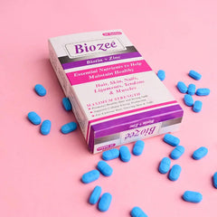 Biozee Biotin + Zinc tablets box with blue tablets on pink background, wellness supplement
