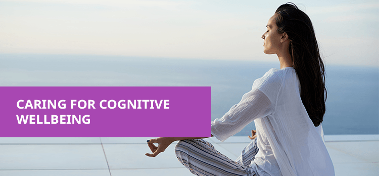 Woman meditating outdoors by the sea, promoting cognitive wellbeing and wellness solutions from Phlox.